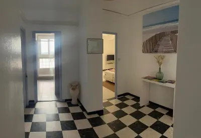 a hallway with a room with a bed and a checkered floor at Ogooué appartement entier Lumineux 94m2 in Carpentras