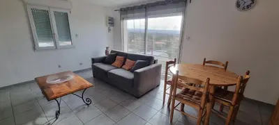 a living room with a couch and a table at Le Mas de la Tortue (Toit Terrasse) in Caromb