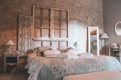 a bedroom with a large bed with a wooden headboard at La Bastide des Songes - Demeure d'hôtes in Robion en Luberon