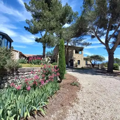 a garden in front of a house with flowers at Le Bastion des Papes in Châteauneuf-de-Gadagne