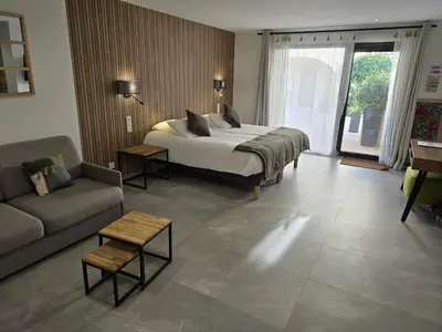 a large bedroom with a bed and a couch at Les Loges du Luberon in Coustellet