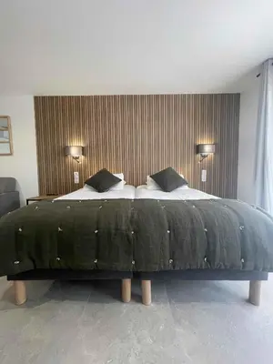 a bedroom with a large bed with two pillows at Les Loges du Luberon in Coustellet