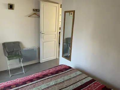 a room with a mirror and a chair and a bed at Gite Les Enfantines in Bédoin