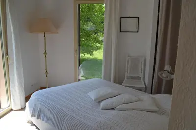 a bedroom with a white bed with a window at Chez MiLy in Sénas