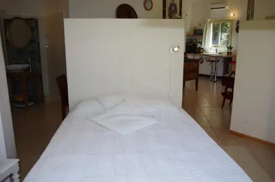 a bed in a room with a white wall at Chez MiLy in Sénas