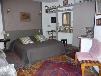 a bedroom with a bed and a living room at La Cordière in Lourmarin