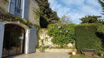 a building with a gate and a bench in front of it at Mas des Prevots B&B in Noves