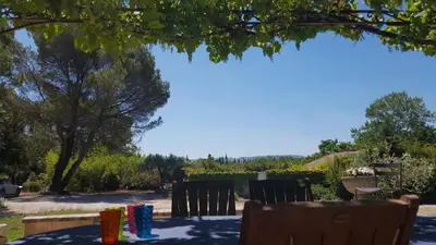 a table with chairs sitting under a tree at Mas des Prevots B&B in Noves