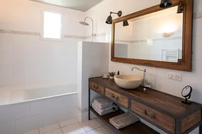 a bathroom with a sink and a mirror and a tub at Mas des Prevots B&B in Noves