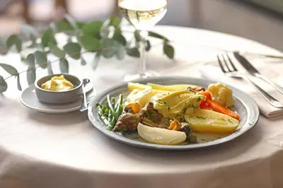 a plate of food on a table with a glass of wine at Negrecoste Hôtel & Spa in Aix-en-Provence