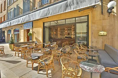 a group of tables and chairs in front of a store at Negrecoste Hôtel & Spa in Aix-en-Provence