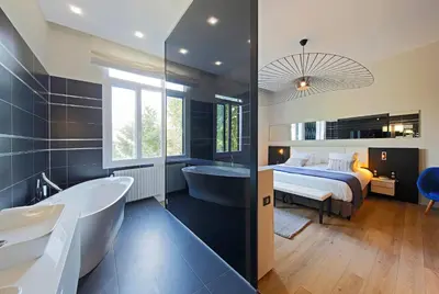 a bathroom with a bed and a bath tub and a bedroom at Negrecoste Hôtel & Spa in Aix-en-Provence