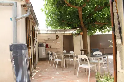 a patio with tables and chairs and a tree at L'atelier B&B in Bédoin
