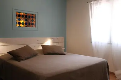 a bedroom with a bed and a window with a picture on the wall at L'atelier B&B in Bédoin
