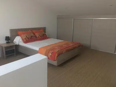a bedroom with a bed with orange pillows at Au bon logis Luberon 50m2 in Cheval-Blanc