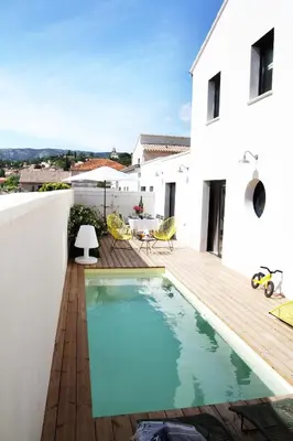 a house with a swimming pool and a wooden deck at Les Loges En Provence 