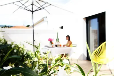 a woman sitting at a table on a patio at Les Loges En Provence 