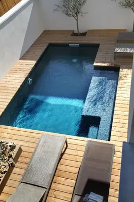 a large swimming pool on a wooden deck at Les Loges En Provence 