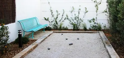 a blue bench sitting in a garden with dominoes at Les Loges En Provence 
