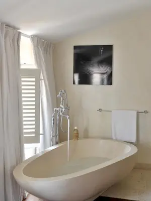 a large white tub in a bathroom with a window at La Maison d'Aix 1785 - Hôtel Particulier & Spa in Aix-en-Provence
