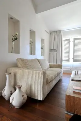 a living room with a couch and two vases on the floor at La Maison d'Aix 1785 - Hôtel Particulier & Spa in Aix-en-Provence