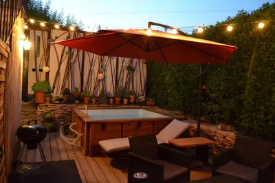 a patio with a hot tub and an umbrella at Pavillon de Lubéron in Lauris