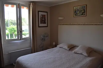 a bedroom with a bed and a window and a fan at Pavillon de Lubéron in Lauris