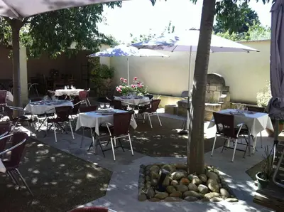 a restaurant with tables and chairs and an umbrella at le clos du Patre in Caromb