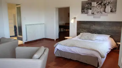 a bedroom with a bed and a couch and a chair at le clos du Patre in Caromb