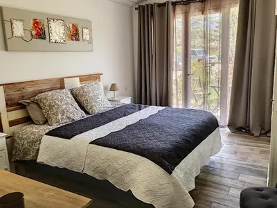 a bedroom with a large bed and a window at La belle histoire Gîte Montmirail in Bédoin