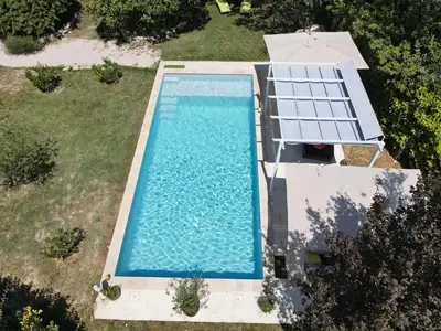 an overhead view of a swimming pool in a backyard at La belle histoire Gîte Montmirail in Bédoin