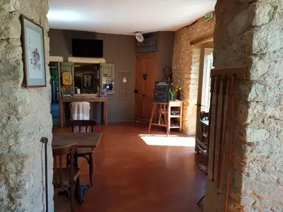 a living room with a table and a kitchen at Le Crillon in Murs