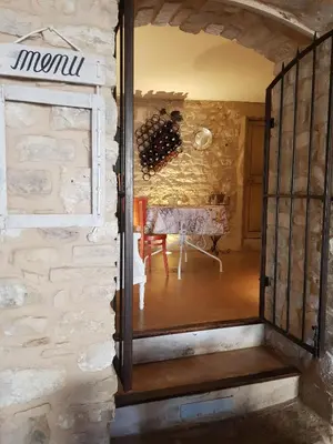 a doorway into a room with a table with wine bottles at Le Crillon in Murs