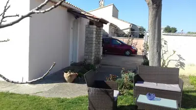 a yard with two chairs and a car in a driveway at Villa Jasmin in Carpentras