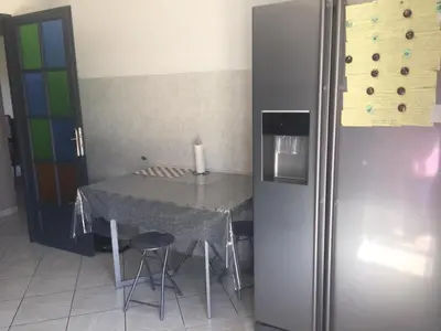 a kitchen with a table and a refrigerator at Villa Jasmin in Carpentras