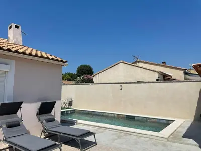 a patio with two chairs and a swimming pool at Villa Jasmin in Carpentras