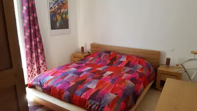 a bed with a colorful comforter in a bedroom at Mas des Mûriers in Saumane-de-Vaucluse