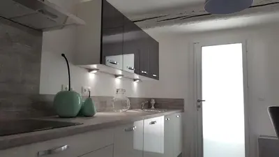a kitchen with white cabinets and a sink and a counter at Mas des Mûriers in Saumane-de-Vaucluse