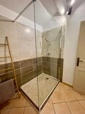 a shower with a glass door in a bathroom at La belle histoire Gîte Ventoux in Bédoin