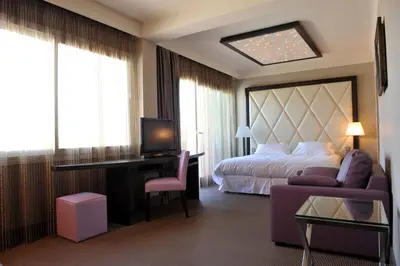 a hotel room with a bed and a desk and a couch at Le Safari Hotel Restaurant in Carpentras