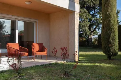 two chairs sitting on a porch next to a house at Hôtel La Perna in Pernes-les-Fontaines