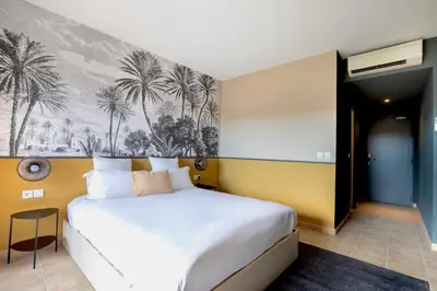 a bedroom with a bed with a painting on the wall at Hôtel La Perna in Pernes-les-Fontaines
