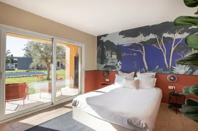 a bedroom with a large bed and a balcony at Hôtel La Perna in Pernes-les-Fontaines