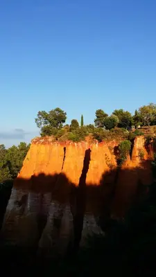 a shadow of a person standing on a cliff at La Dame Au Balcon in Roussillon