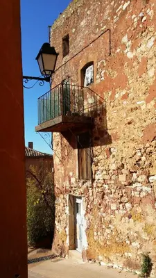 a building with a balcony on the side of it at La Dame Au Balcon in Roussillon