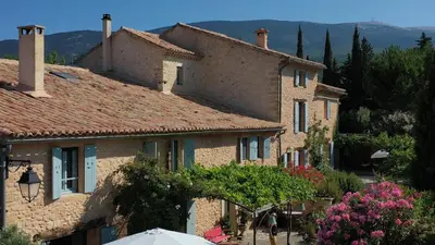 a group of stone houses with trees and flowers at Mas des Olives in Bédoin
