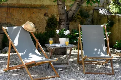 two lawn chairs and a table with a hat on them at Mas des Olives in Bédoin