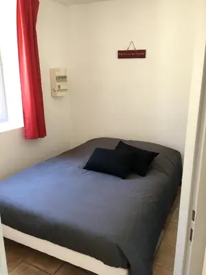 a bed in a small room with a sign on the wall at Séjour Authentique et provençal in Fontaine-de-Vaucluse
