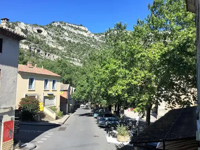 a street in a town with a mountain in the background at Séjour Authentique et provençal in Fontaine-de-Vaucluse