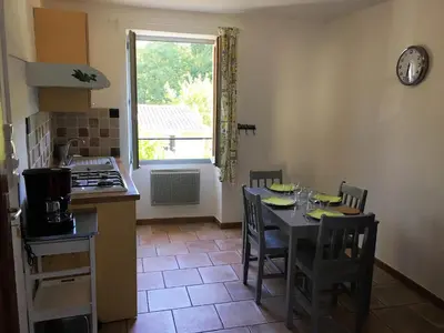 a kitchen with a table and chairs and a window at Séjour Authentique et provençal in Fontaine-de-Vaucluse